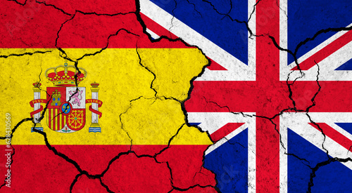 Flags of Spain and United Kingdom on cracked surface - politics, relationship concept