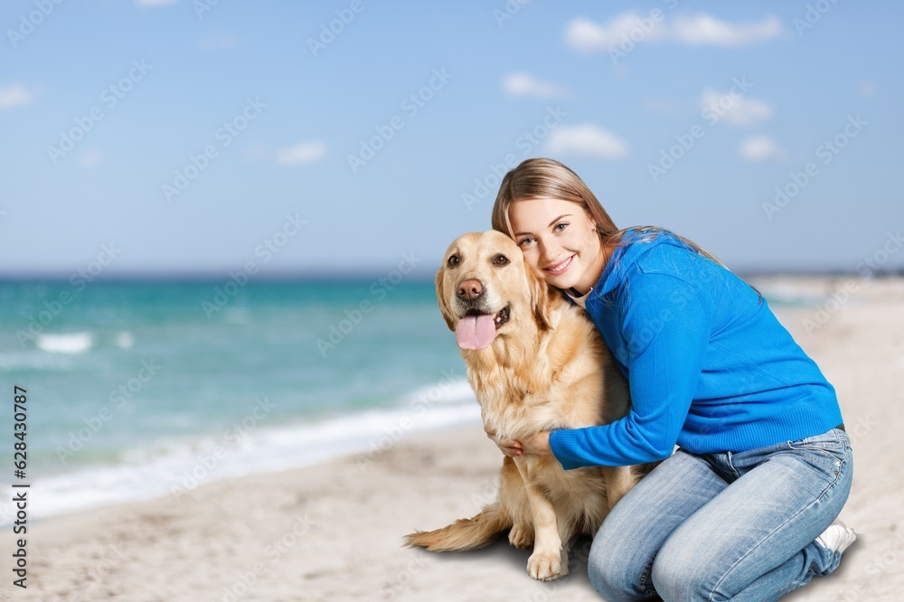 Happy young  woman at beach with cute dog