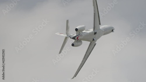 Large white private business Jet during flight under blue sky with clouds