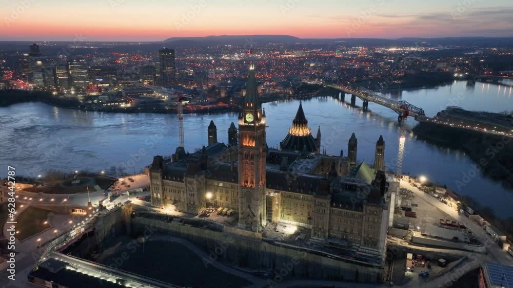 A striking evening drone shot of the Parliament buildings with Gatineau in the background. Shot during sunset with beautiful colour in the sky and a slow dolly pan around the peace tower