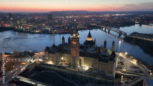 A striking evening drone shot of the Parliament buildings with Gatineau in the background. Shot during sunset with beautiful colour in the sky and a slow dolly pan around the peace tower photo