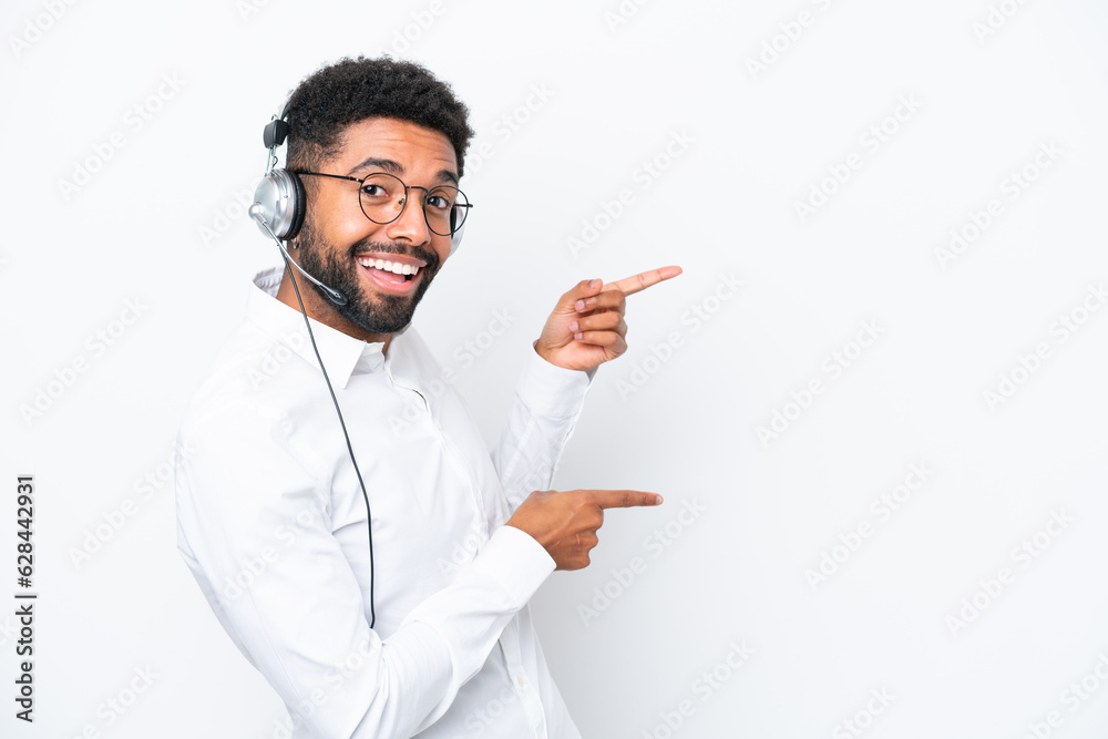Telemarketer Brazilian man working with a headset isolated on white background pointing finger to the side and presenting a product Telemarketer Brazilian man working with a headset isolated on white background pointing finger to the side and presenting a product