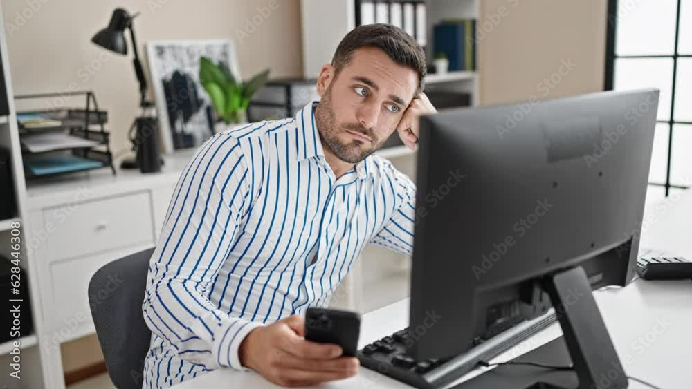 Young hispanic man business worker boring using smartphone at office Young hispanic man business worker boring using smartphone at office