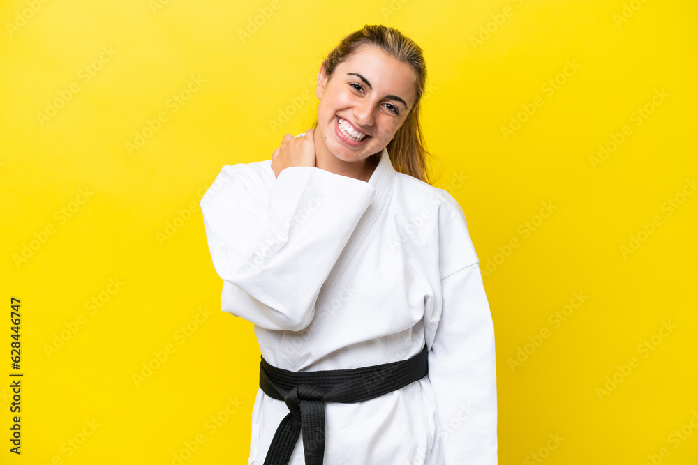 Young caucasian woman doing karate isolated on yellow background laughing Young caucasian woman doing karate isolated on yellow background laughing