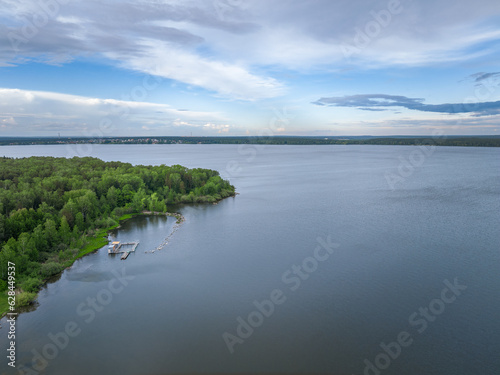 Big lake with green shores in bright sun light, aerial landscape. Recreation concept. Aerial view