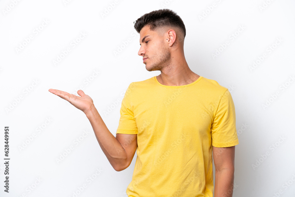 Young caucasian man isolated on white background holding copyspace with doubts Young caucasian man isolated on white background holding copyspace with doubts