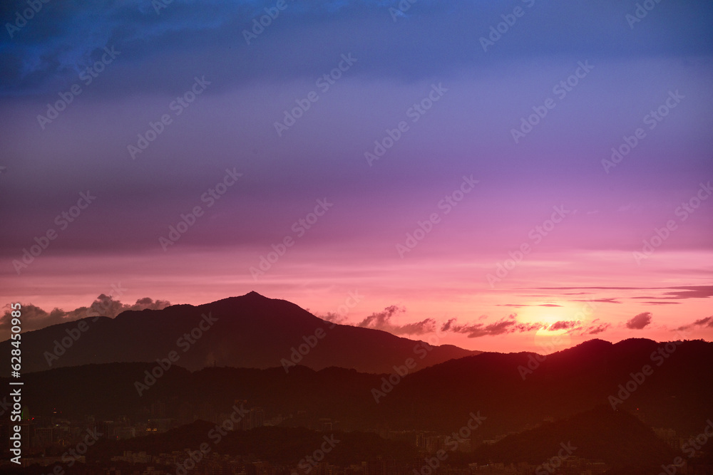 The orange-red sun emerged from the clouds and moved toward the horizon. View of the urban landscape from Dajianshan Mountain, New Taipei City. The orange-red sun emerged from the clouds and moved toward the horizon. View of the urban landscape from Dajianshan Mountain, New Taipei City.