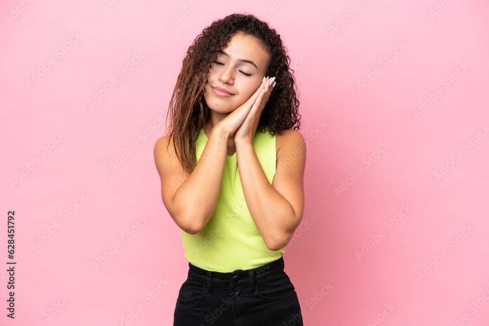 Young hispanic woman isolated on pink background making sleep gesture in dorable expression Young hispanic woman isolated on pink background making sleep gesture in dorable expression