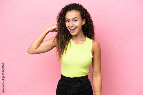 Young hispanic woman isolated on pink background doing strong gesture