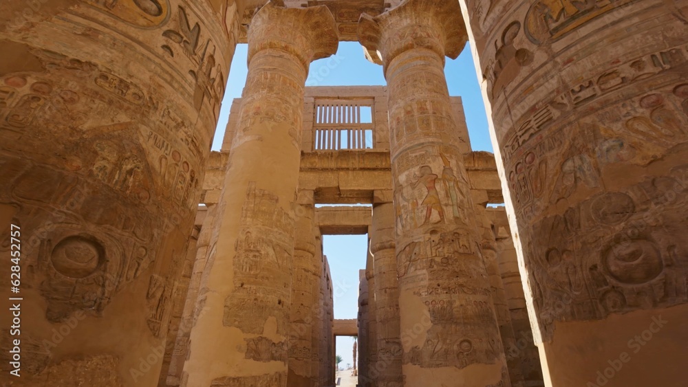 Karnak Temple in Luxor, Egypt. Camera moves between majestic columns with ancient Egyptian drawings. Gimbal high quality shot