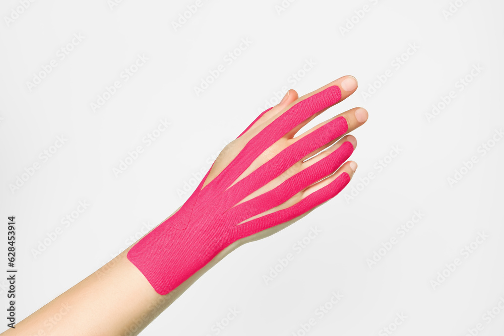 aesthetic hand taping. female hand with pink kinesio tape. hand skin
