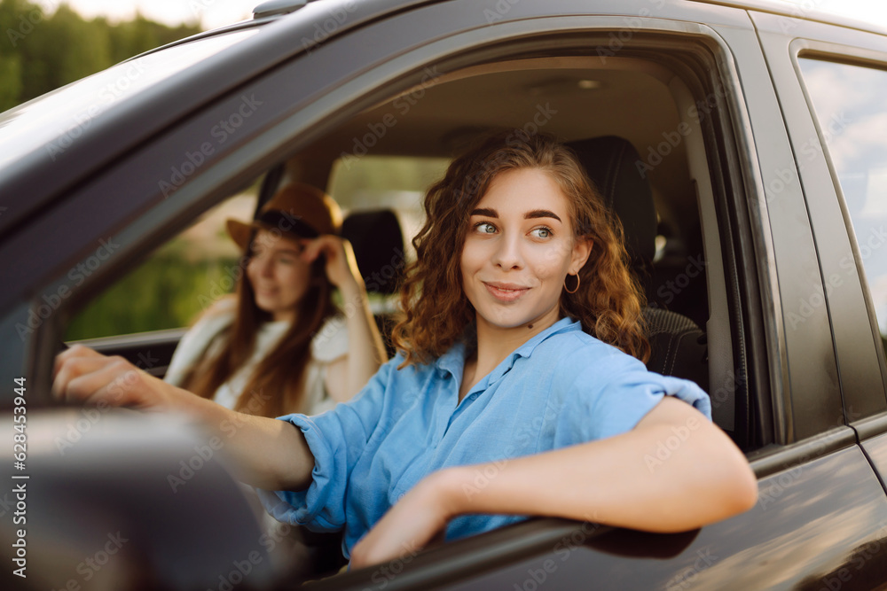 Portrait of two young women on a car trip having fun, smiling, chatting together, enjoying nature. Active lifestyle, travel, tourism, nature. Portrait of two young women on a car trip having fun, smiling, chatting together, enjoying nature. Active lifestyle, travel, tourism, nature.