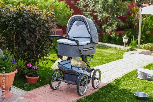a gray baby stroller is standing on the lawn