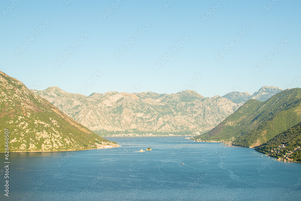 Mountains along the sea coast on a sunny day. Kotor bay seascape. Beauty of nature concept background.