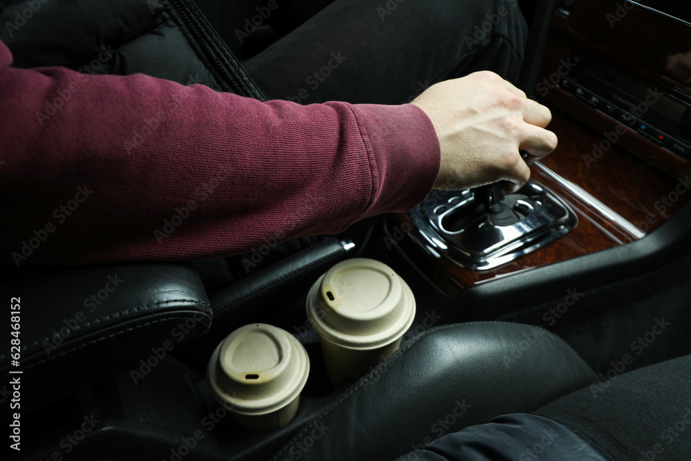 Hot coffee in the interior of the car, near the driver