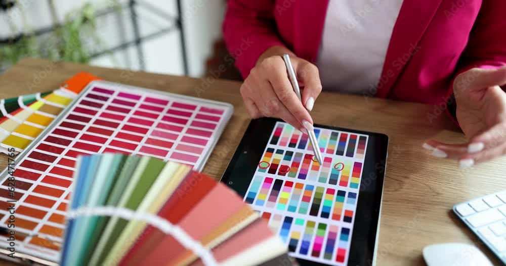 Graphic designer with client studies color palettes on tablet. Color circles color selection for interior on tablet closeup of hand