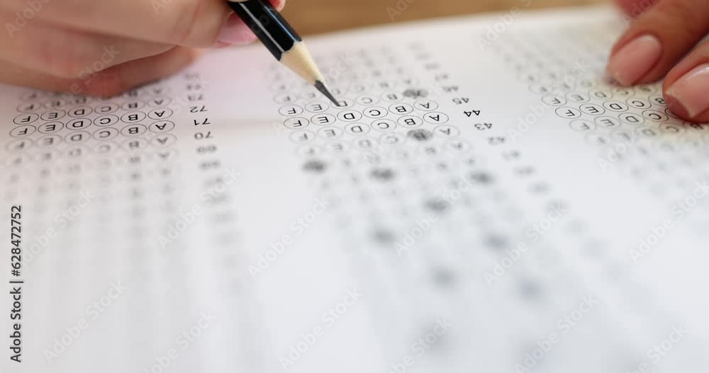 Person solves tests and writes with pencil on paper. Multiple choice exam or student testing