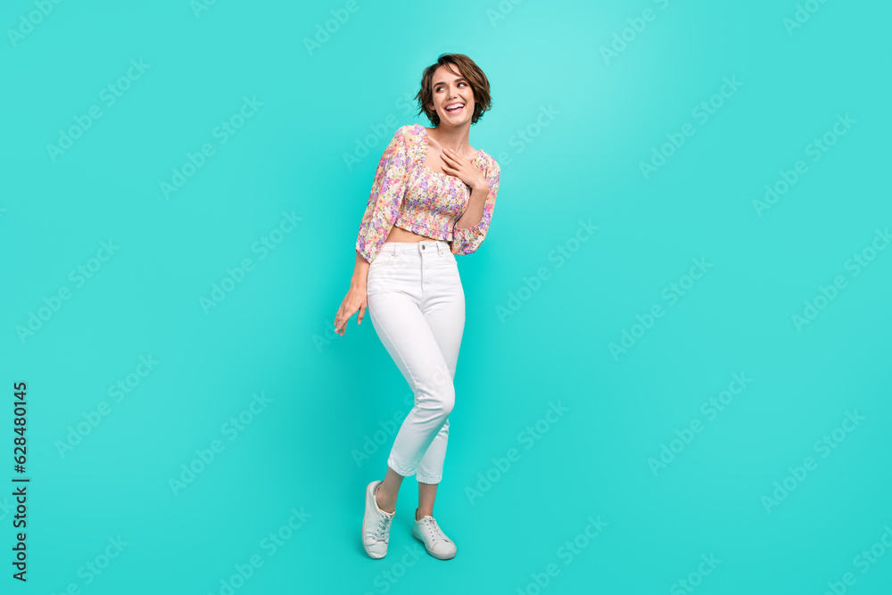 Full size portrait of gorgeous cheerful shy girl hand touch chest look empty space isolated on turquoise color background Full size portrait of gorgeous cheerful shy girl hand touch chest look empty space isolated on turquoise color background