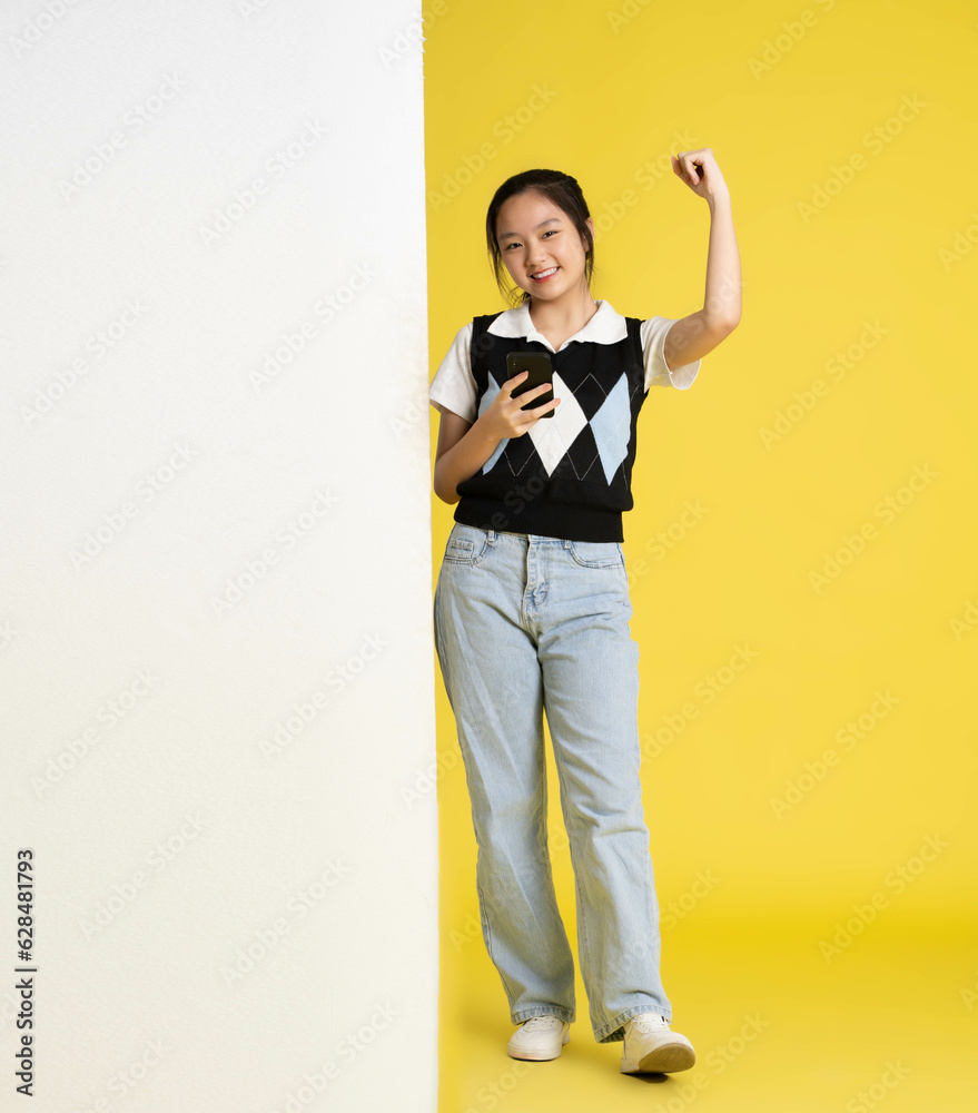image of asian girl standing and using phone with billboard image of asian girl standing and using phone with billboard