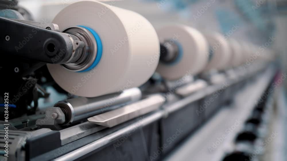 Close-up spools of yarn thread. Textile factory equipment. Threads production. Textile factory. Spinning production. Yarn making processes Close-up spools of yarn thread. Textile factory equipment. Threads production. Textile factory. Spinning production. Yarn making processes