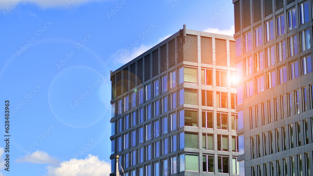 Structural glass wall reflecting blue sky. Abstract modern architecture fragment. Glass building with transparent facade of the building and blue sky. Contemporary architectural background. Structural glass wall reflecting blue sky. Abstract modern architecture fragment. Glass building with transparent facade of the building and blue sky. Contemporary architectural background.
