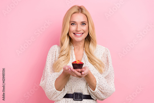 Photo portrait of pretty blonde female hold sweet maffin tasty food wear trendy white outfit isolated on pink color background