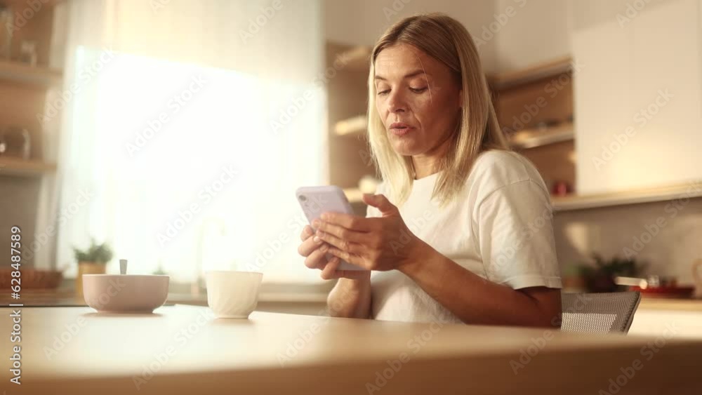 Charming mature blond woman drinking coffee while get notification on smartphone and celebrate online win success reading great news message feel amazed happy outdoors Triumph Lucky Wow concept Charming mature blond woman drinking coffee while get notification on smartphone and celebrate online win success reading great news message feel amazed happy outdoors Triumph Lucky Wow concept