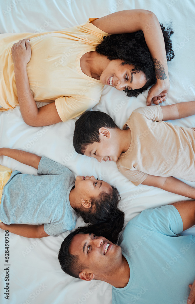 Top view of mother, father and children in bed for bonding, quality time and affection in morning. Happy, love and above of mom, dad and kids in bedroom for fun, sleeping and relax together at home