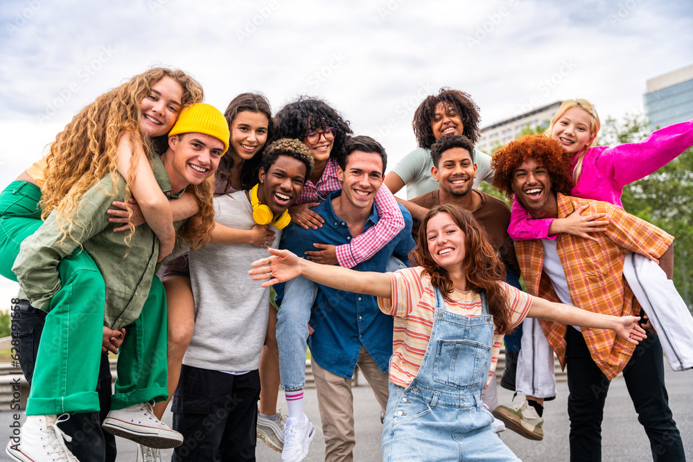 Happy playful multiethnic group of young friends bonding outdoors - Multiracial millennials students meeting in the city, concepts of youth, people lifestyle, diversity, teenage and urban life - obrazy, fototapety, plakaty 