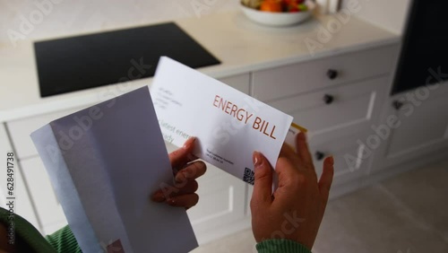 Close up of woman at home opening Euro energy bill during cost of living crisis - shot in slow motion photo