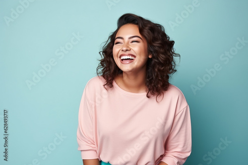 plus sized Latina woman smiling on a blue background studio shot