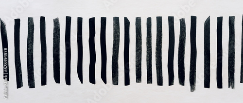 immagine primo piano di spesse righe verticali in inchiostro nero su carta ruvida, vista dall'alto photo