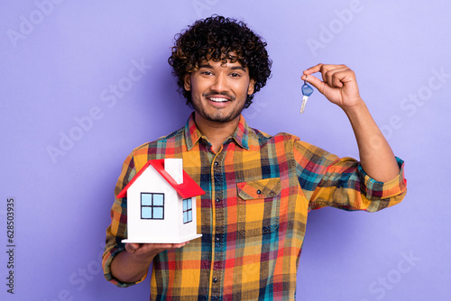 Photo of positive successful man hand hold demonstrate little house key isolated on violet color background