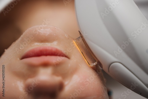 Phototherapy, photorejuvenation, IPL in a beauty salon. Care for a woman's face.