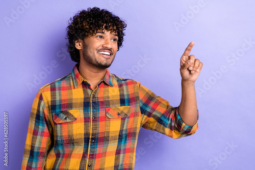 Photo of handsome man perming coiffure dressed plaid shirt directing look at offer empty space isolated on purple color background
