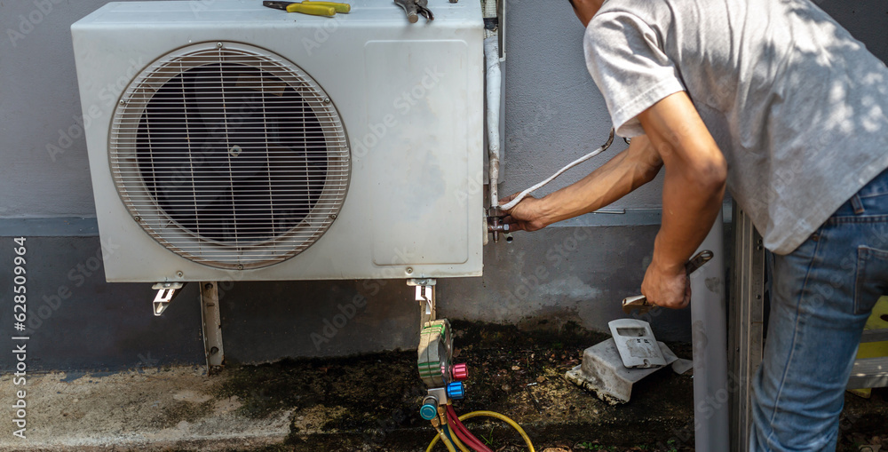 The electrician repairing the air conditioner, Technician is checking the coolness air compressor The electrician repairing the air conditioner, Technician is checking the coolness air compressor