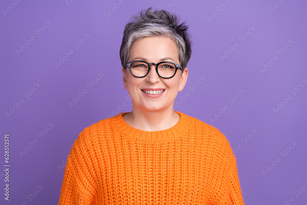 Photo of satisfied optimistic friendly woman with short haircut dressed orange sweater smiling isolated on purple color background Photo of satisfied optimistic friendly woman with short haircut dressed orange sweater smiling isolated on purple color background