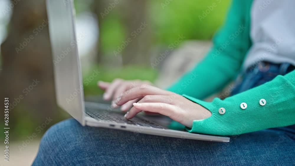 Young chinese woman using laptop sitting on bench at park Young chinese woman using laptop sitting on bench at park