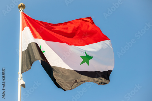 Syria flag in the blue sky. horizontal panoramic banner. Close-up of waving Syrian flag. Great photo for news illustrations.