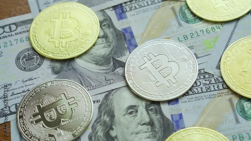 Gold and silver bitcoin coins lie on the table with dollars close up