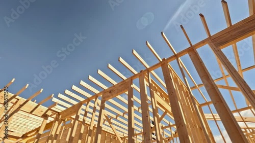 At construction site there are beams of wood stick framing that will be used to construct new house