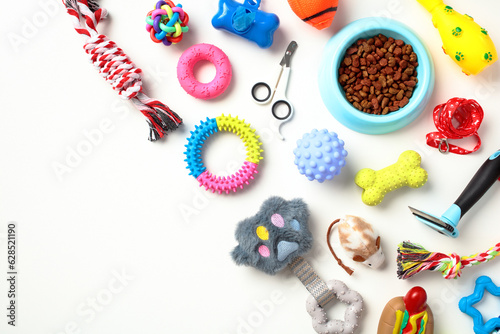 Fototapeta Different pet supplies and toys, bowl of dry food on white background