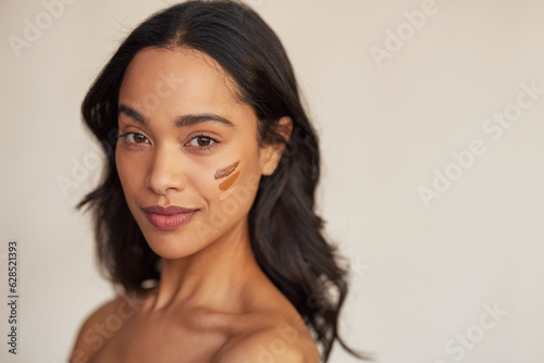 Beautiful mixed race woman trying foundation shades on cheek