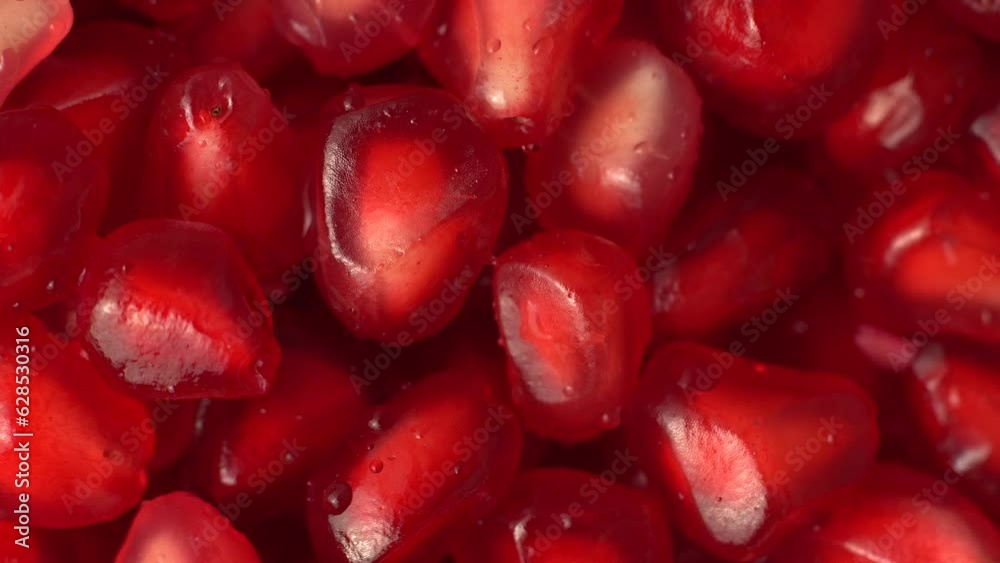360 Degree rotation of pomegranate fruit on white background. Close up video of pomegranates on plain white surface.