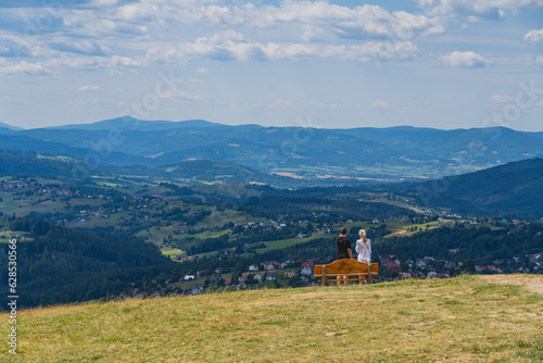 Fototapeta Naklejka Na Ścianę i Meble -  People looking from the top of the Ochodzita mountain to the Beskidy Mountains.