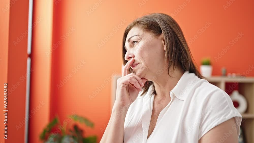 Middle age hispanic woman worried with hand on face at home Middle age hispanic woman worried with hand on face at home