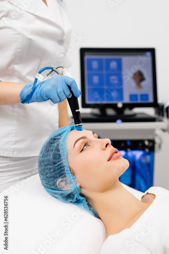 Beauty therapist performing hydrafacial procedure on woman