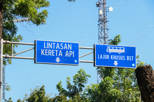 Sign for railroad tracks and bus lane on highway