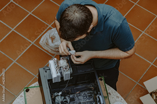 Technician repair assembles computer at home. Computer repair, assembling a personal computer. Working from home. Technology background. Pc build. Installing Hardware components.