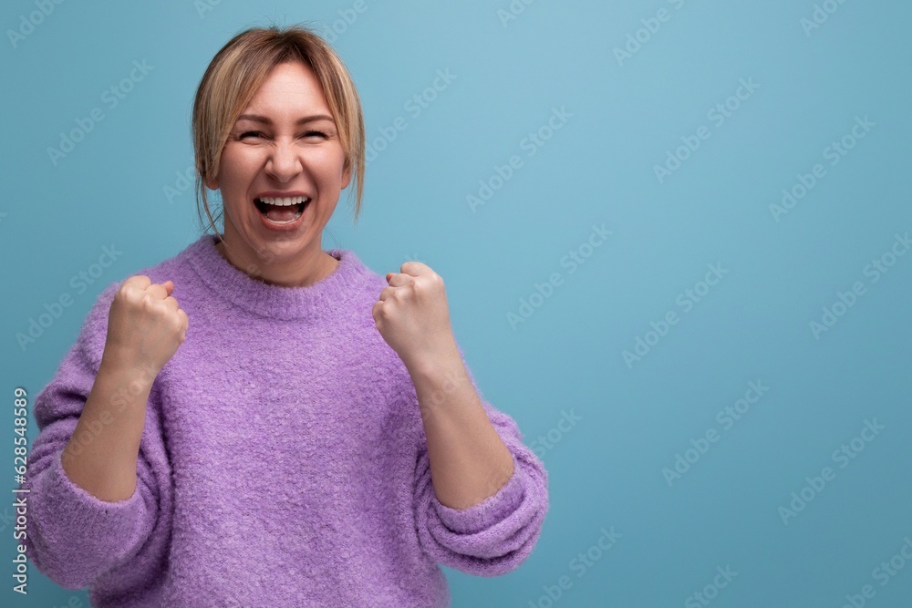 charming winner blonde young millennial woman in casual look screaming with joy on a bright background with copy space charming winner blonde young millennial woman in casual look screaming with joy on a bright background with copy space